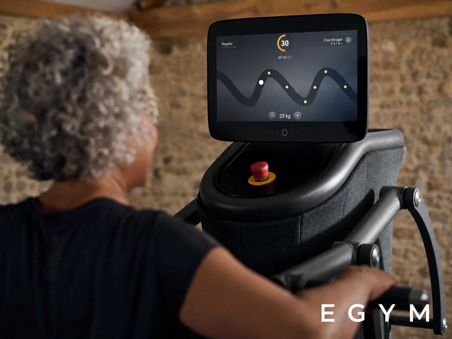 EGYM connected strength machine and training screen in an edited barn setting