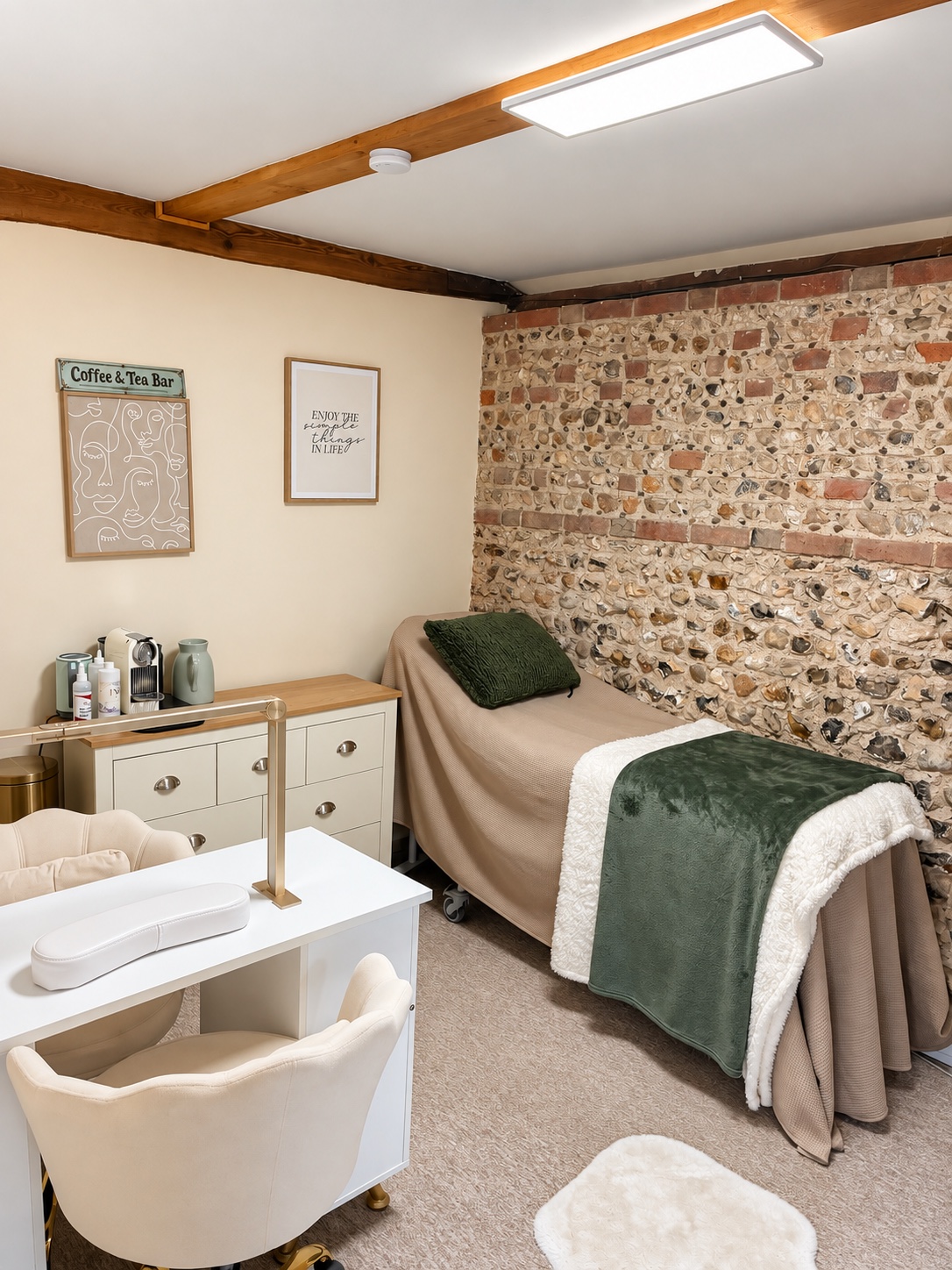 A private Astons Wellness Room with a treatment couch, manicure table and original flint wall